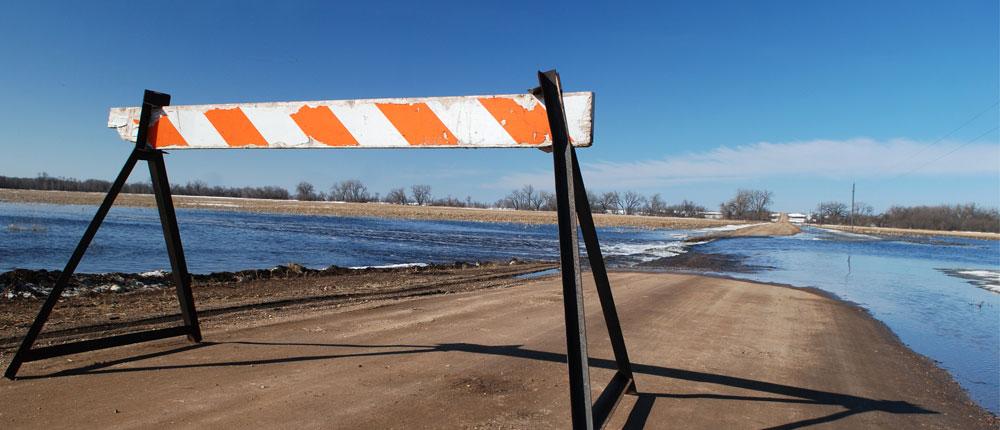 一个路障标志阻止汽车在被洪水淹没的道路上行驶.